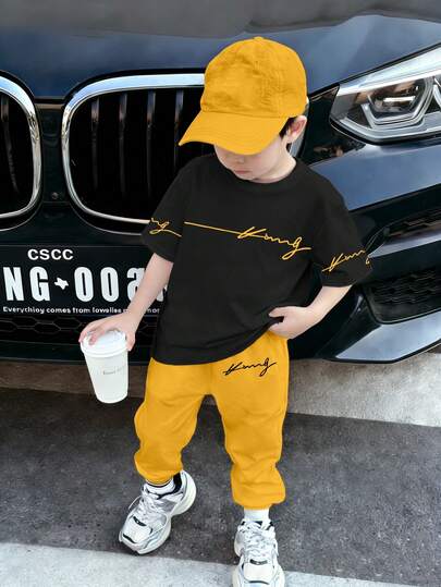 SHEIN Streecool Kids 2pcs/Set Young Boys Letter & Graphic Print Outfit, Fashion Versatile Casual Comfortable Black Round Neck T-Shirt & Yellow Pants, Boys Short Sleeve Top & Trousers Set, Suitable For All Seasons