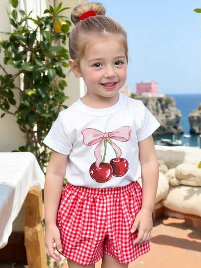SHEIN Playful Pals Baby Girls' Cute Bow & Cherry Print Design Outfit, Featuring Red Plaid Shorts And Short Sleeve T-Shirt Set, Fashionable Casual Comfortable Outfit Suitable For Parties, Gatherings In Spring And Summer, Lightweight And Comfortable Summer Wear, Fashionable Casual Streetwear, Suitable For Outdoor Picnics, Street Photography, Campus, Festivals, And Gifts