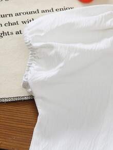 SHEIN Vintaside Kids 这款女童夏季短袖衬衫采用白色纹理面料，领口为彼得潘领设计，饰有精致的白色缝线，领子边缘点缀着白色刺绣草莓图案，领子两侧绣有红色草莓和绿色叶子，增添了一丝俏皮感。短袖采用泡泡袖设计，衬衫前襟有一排白色纽扣，整体风格甜美可爱，非常适合小女孩日常穿着。 - 白色 - 查看 7