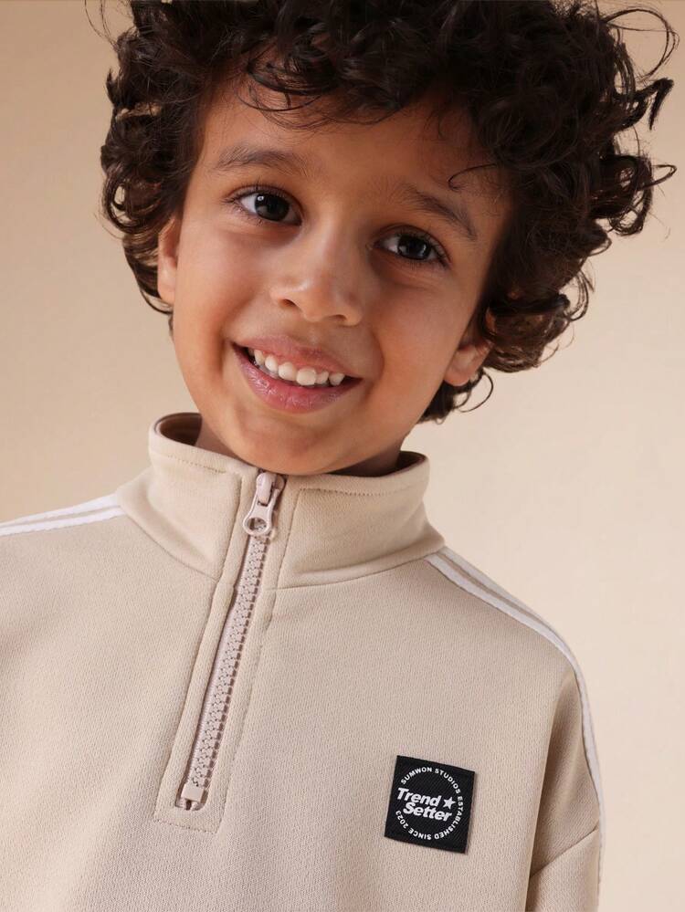 Komplet składający się z bluzy z kapturem i spodenek z suwakiem i detalami w paski