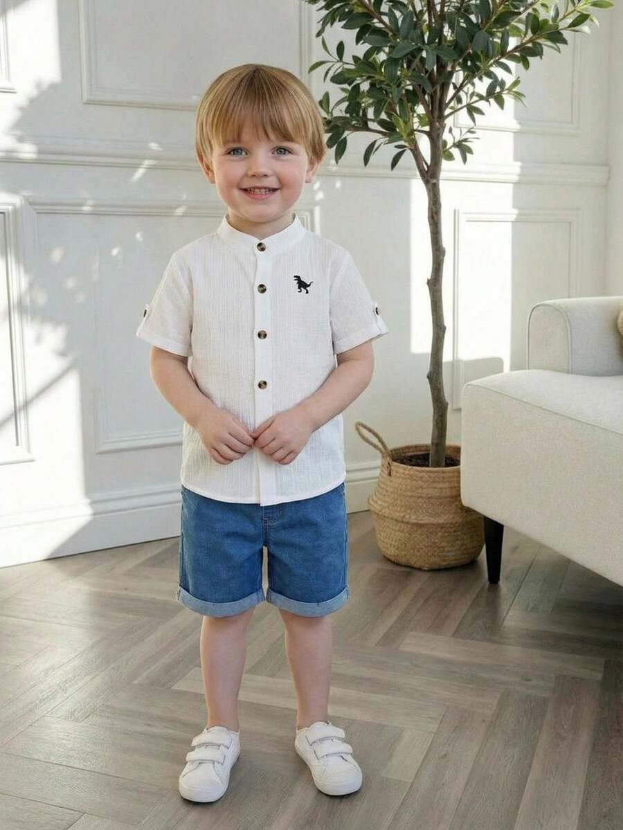 Souflis Souflis 两件套儿童男童校服，包括一件白色短袖衬衫（棕色纽扣，黑色恐龙印花）和一条蓝色束口短裤。舒适休闲，适合日常穿着。 - 白色 - 查看 1