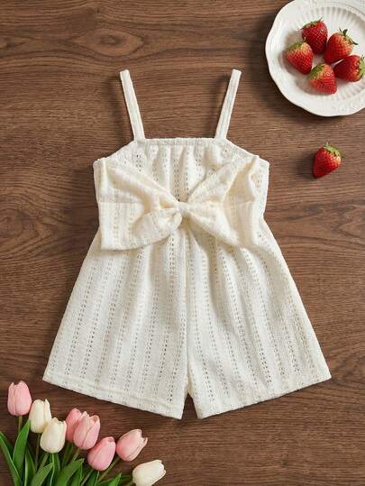 SHEIN Playful Pals 1pc Baby Girl Cute Sweet Bohemian Fashion Casual White Cream Solid Color Large Bow Knot Decor Hollow Out Eyelet Textured Knit Pattern Sleeveless Spaghetti Strap Camisole Style Romper Jumpsuit Jumpsuit Playsuit Shorts One Piece Soft Clothes For Beach Vacation Holiday Party Photo Shoot Daily Wear Summer Spring