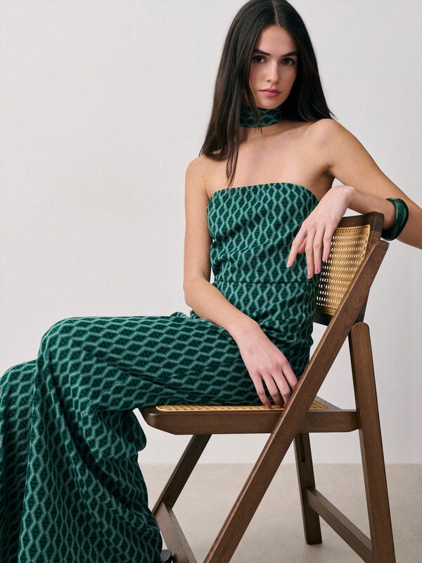 Nöista Off Shoulder Jumpsuit With A Geometric Jacquard Fabric, Fitted Bodice, Wide-Leg Pants And Matching Choker On Neck. Spring, Summer, Wedding Occasion, Formal Event, Easter.