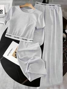 SHEIN 这款女童休闲运动风两件套上衣采用浅灰色弹力舒适针织面料，圆领短袖设计，搭配宽松直筒裤。提花字母图案增添独特韵味，使其成为日常穿着、上学、运动、旅行等各种场合的理想之选。适合春秋两季穿着。 - 灰色 - 查看 1