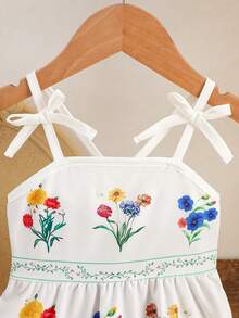 SHEIN Vestido avental infantil com estampa floral, tecido leve e macio, alças com laço, estampa floral colorida, amarração na cintura, modelagem solta e fluida, ideal para piqueniques ao ar livre, brincadeiras no jardim e para a primavera/verão. - Branco - Ver 4