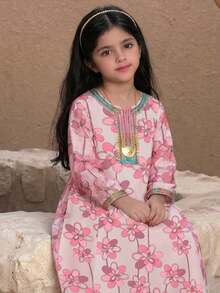 Vestido rosa para niñas preadolescentes, hecho de tela suave para un uso cómodo. El Body del vestido es de un tono rosa suave, con volantes blancos en los hombros decorados con flores rosas, agregando un toque. El vestido también presenta un lindo estampado de muñeca, dando una sensación juguetona. Este vestido ligero es perfecto para ocasiones de primavera/verano como fiestas y salidas - Multicolor - Ver 1