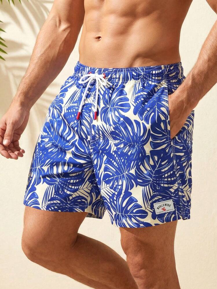Manfinity Swimmode Shorts de playa con estampado de plantas tropicales, cintura con cordón y bolsillos para hombres - Azul - Añade 8