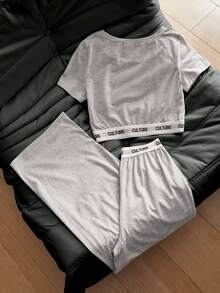 SHEIN 这款女童休闲运动风两件套上衣采用浅灰色弹力舒适针织面料，圆领短袖设计，搭配宽松直筒裤。提花字母图案增添独特韵味，使其成为日常穿着、上学、运动、旅行等各种场合的理想之选。适合春秋两季穿着。 - 灰色 - 查看 2