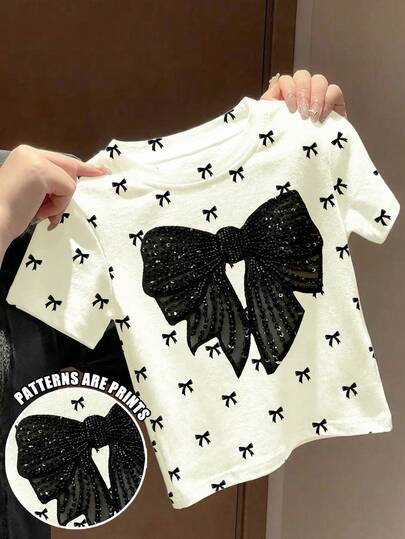 SHEIN 可爱芭蕾舞风格迷你蝴蝶结印花，优雅黑色蝴蝶结图案，时尚别致，女童休闲简约短袖圆领上衣，适合夏季穿着，可爱夏季穿搭，夏季童装，夏季外出服，韩版风格，返校季，舒适时尚童装，春夏穿搭，休闲服饰，婴幼儿印花上衣，夏季新款，春夏时尚