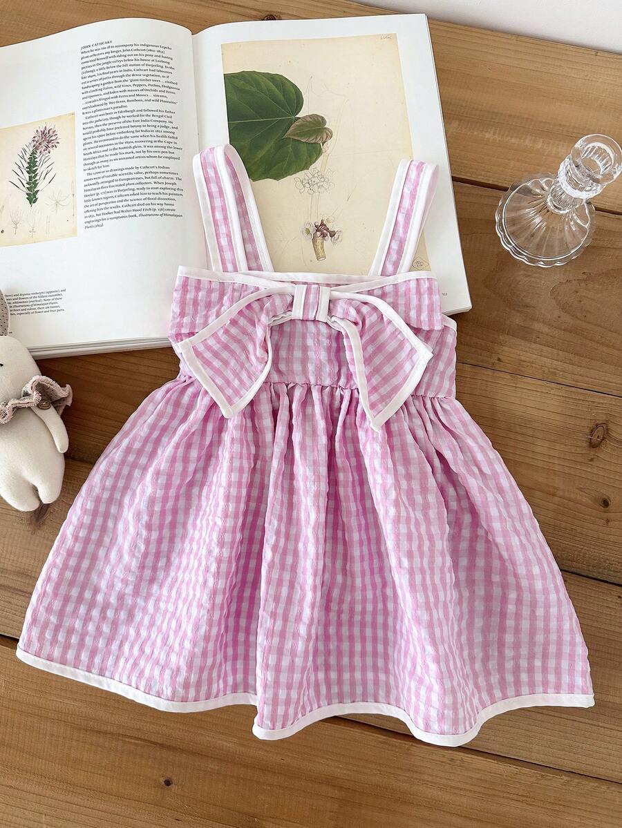 SHEIN 这款女婴夏季粉色格子纹理面料吊带连衣裙，胸前饰有大型立体蝴蝶结，是度假的完美之选。 - 粉色 - 查看 1