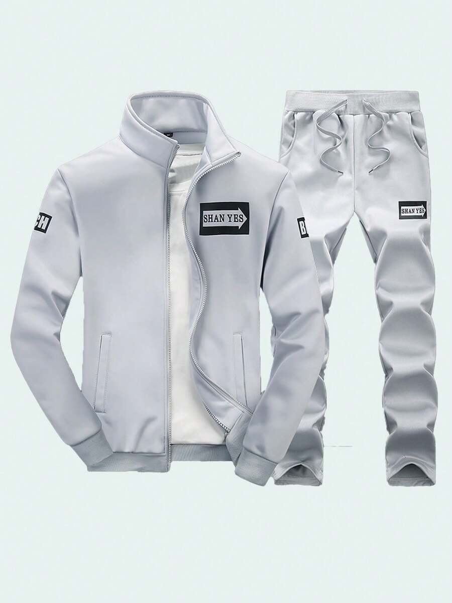 Conjunto de camiseta de manga larga con cuello alto y pantalones de chándal de colores lisos para hombre, ideal para otoño/invierno. Con letras estampadas en los puños y el dobladillo acanalados. Tejido suave y cómodo. Mangas largas con cremallera y cintura con cordón. Corte entallado pero holgado, ideal para actividades al aire libre. Conjunto de dos piezas. - Plateado - Ver 1