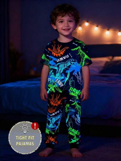 Conjunto de pijama de manga corta ajustado que brilla en la oscuridad con gráfico de dinosaurio y neón para niño pequeño, estampado aleatorio