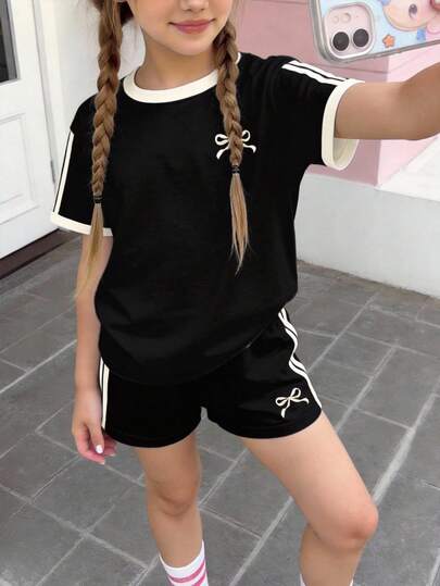 2件套少女休闲蝴蝶结图案T恤和条纹短裤套装，适合春夏日常穿着、街头风、居家休闲、度假穿着。