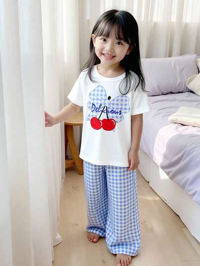 Conjunto de camiseta y pantalones para niñas (talla pequeña) de primavera/verano, estilo casual y sencillo. La camiseta tiene un estampado digital de cuadros azules y blancos con cerezas rojas en la parte delantera, de tela de punto de color blanco liso con cuello redondo y mangas cortas. Los pantalones son de tela tejida con estampado de cuadros azules y blancos, de corte ancho y casual. Adecuado para niñas jóvenes, con estilo coreano, minimalista y cómodo, para uso diario, escuela, salidas, vacaciones, fiestas y primavera/verano.