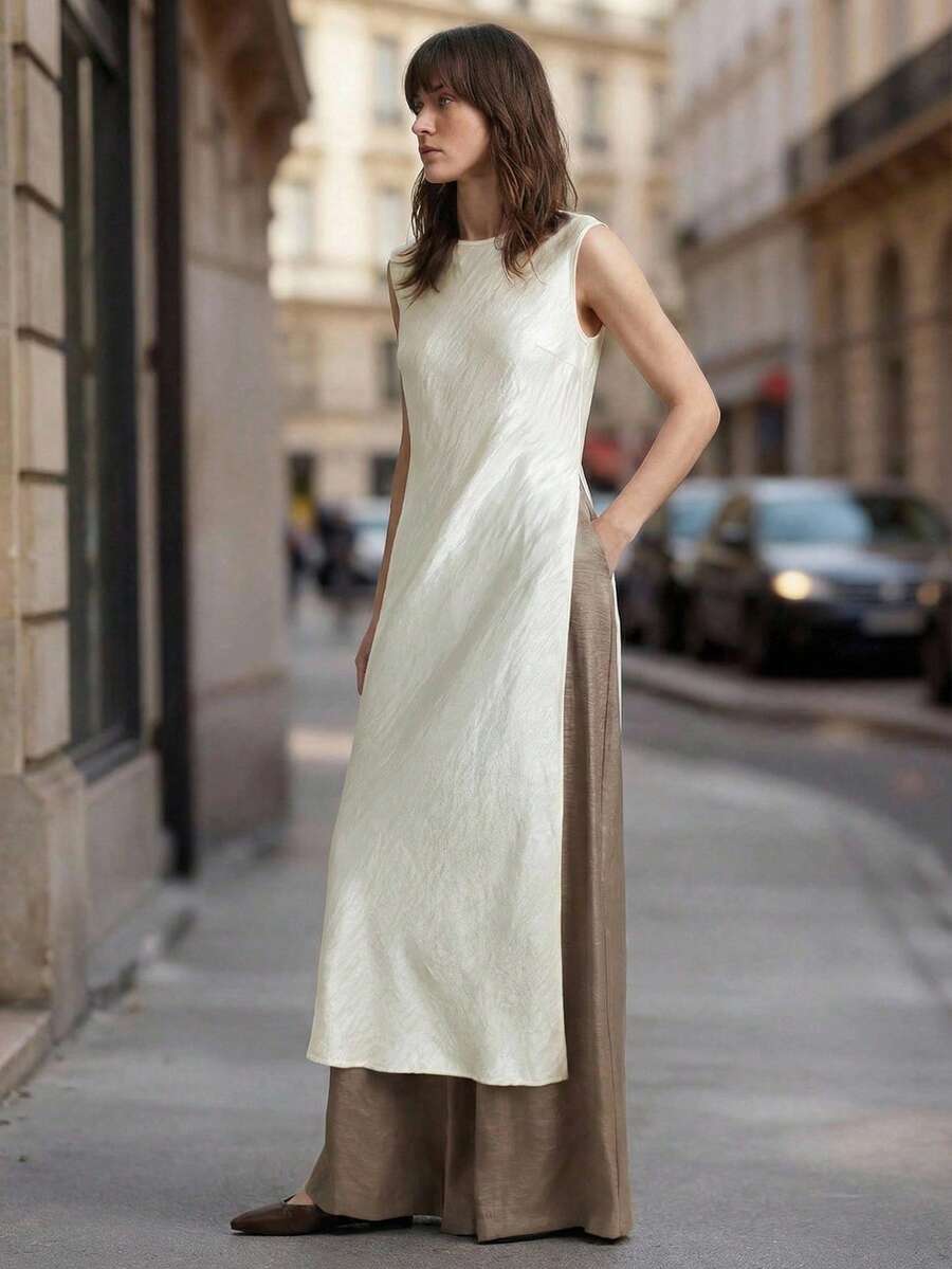 Ontre Áo nữ 2026SS màu mơ nhạt, chất liệu satin nhăn, cổ nhỏ, thiết kế trễ vai tròn, xẻ tà cao bất đối xứng, phong cách hiện đại, năng động, công sở, thời trang sân bay cao cấp, chất liệu satin mềm mại, rủ đẹp.