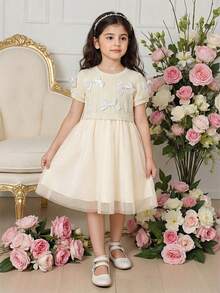 SHEIN Đầm liền thân mùa hè cho bé gái, áo dệt kim tay ngắn màu mơ trang trí nhiều nơ trắng, viền lưới cùng màu, kiểu dáng ngọt ngào và dễ thương, tối giản và thời trang, thoải mái và giản dị cho các hoạt động ngoài trời mùa hè. Đầm màu kem cho bé gái. Đầm màu trắng ngà cho bé gái. - Màu be - Xem 3