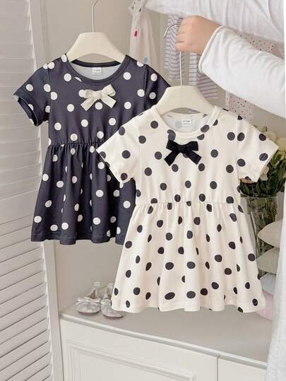 这款女童黑色杏色撞色圆领短袖A字波点连衣裙两件套，简约优雅，甜美复古，充满校园风情。针织面料，厚度适中，宽松版型，领口饰有蝴蝶结织带，波点印花图案更添复古甜美气息。适合日常出行、学校学习、生日派对、儿童节等各种庆祝活动。