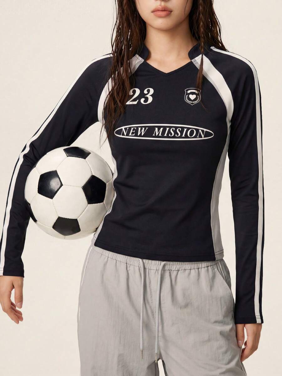 Rina Fox 女士黑色长袖V领插肩袖运动上衣，侧边饰有条纹，印有23号、“NEW MISSION”字样和徽章标志 - 修身弹力足球衫风格休闲街头T恤 - 黑色 - 查看 1