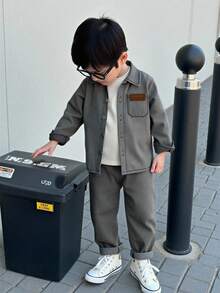 Genkimix Kids 这款男童休闲长袖牛仔套装，采用简约宽松的翻领设计，正面饰有棕色压纹字母印花和实用小口袋，搭配舒适的休闲裤，尽显简约优雅。适合春秋季日常穿着、上学、旅行和休闲活动，是必备的基础牛仔套装。 - 黑色 - 查看 3