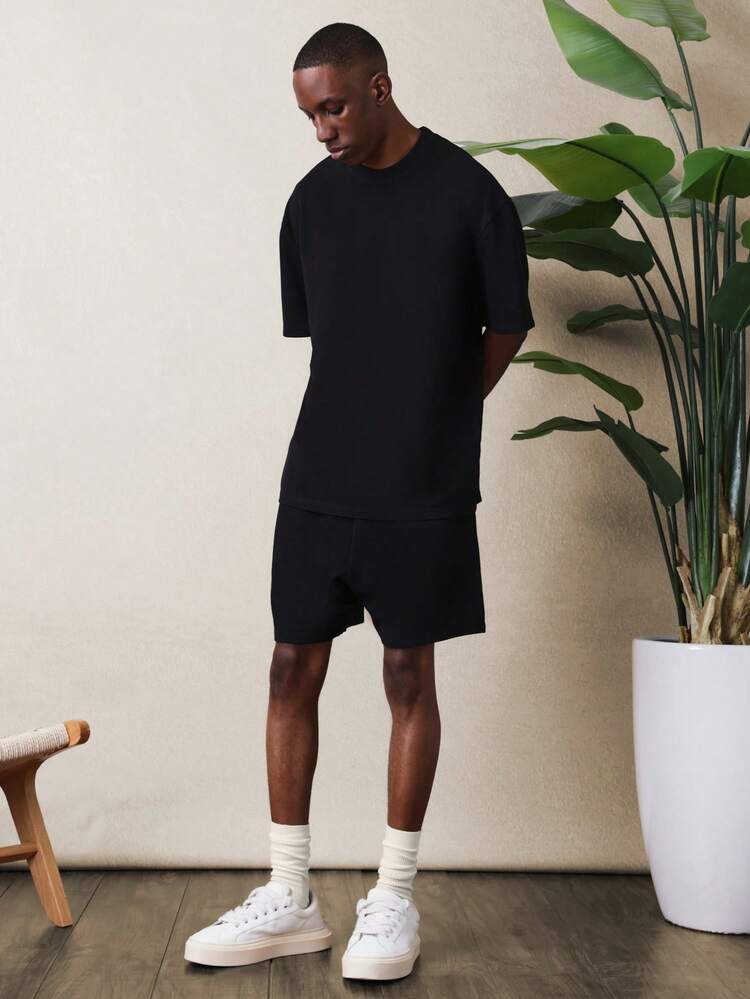 SUMWON Ensemble coordonné homme avec t-shirt oversize col rond noir et short décontracté avec imprimé texte au dos
