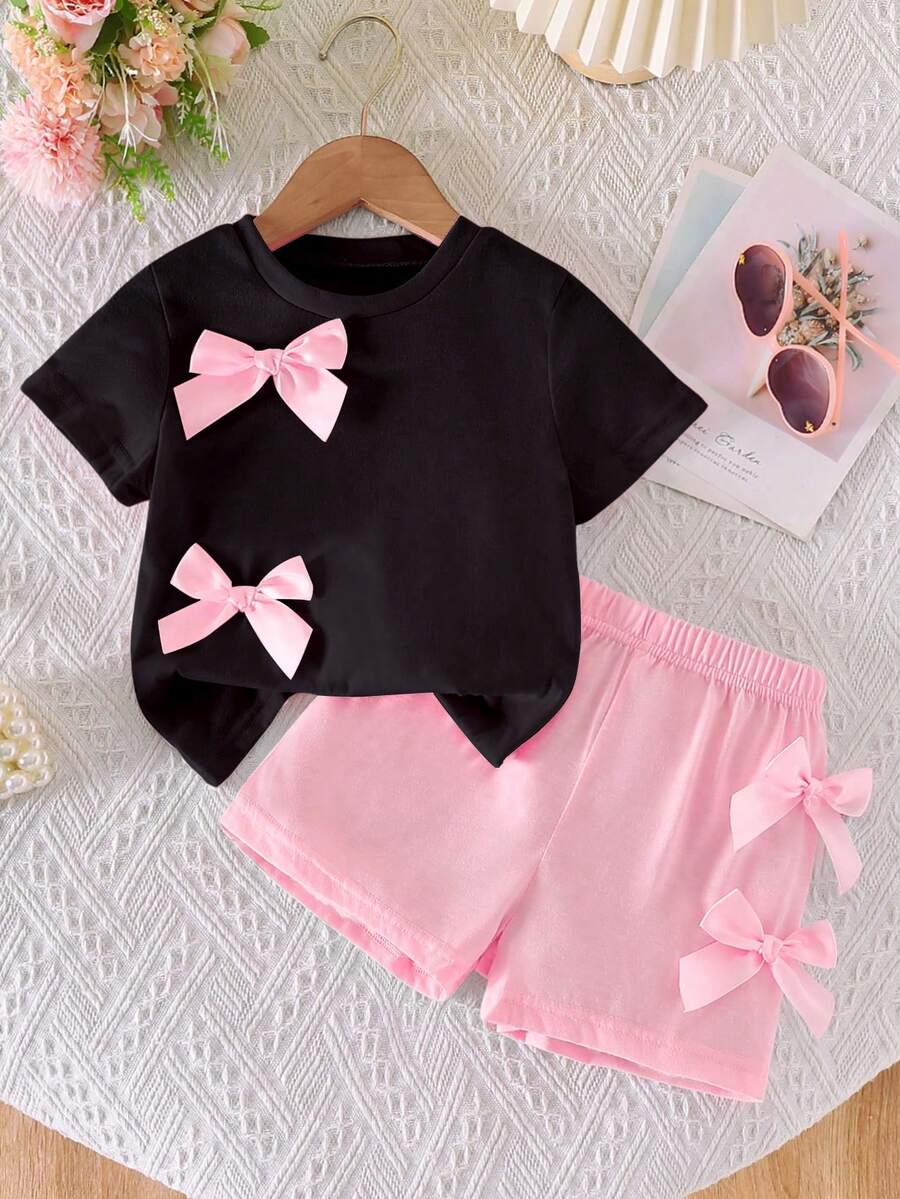 SHEIN Set de 2 piezas: Blusa de manga corta de cuello redondo casual y dulce con decoración de lazo 3D y shorts de cintura elástica para niñas - Multicolor - Ver 1
