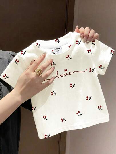 SHEIN 女婴可爱芭蕾舞灵感迷你樱桃印花，手写情书图案，时尚优雅的韩版风格，女婴休闲简约短袖圆领上衣，适合夏季穿着，可爱夏日穿搭，夏季儿童单品，夏季外出必备，韩版风格，返校季，舒适百搭，时尚童装，春夏穿搭，休闲服饰，婴幼儿印花上衣，夏季新款，春夏时尚