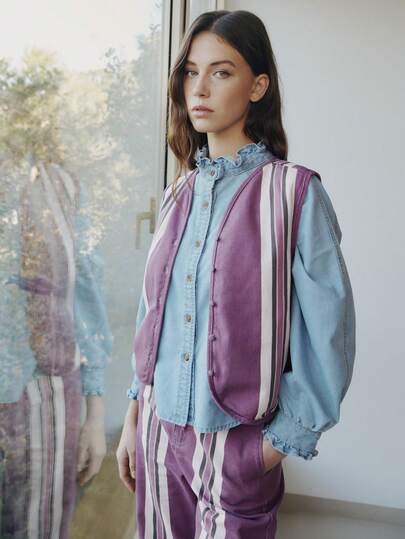 Nöista Sleeveless Button-Up Vest Featuring Vertical Stripes In Purple, White, And Dark Tones. Lightweight, Casual Design With A Rounded Neckline And Fabric-Covered Buttons, The Coordinated Set, Spring, Summer, Looks, Women, Outfits.