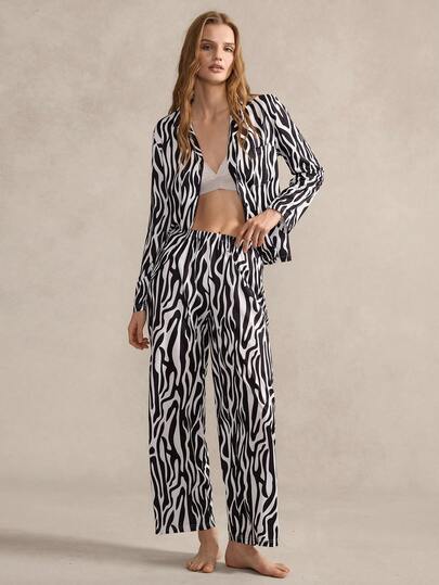 EverLounge 女士睡衣套装，以经典的黑白斑马纹为主图案，采用翻领设计、开襟款式和简约的口袋细节。舒适的睡衣功能性与前卫的动物纹元素相结合，兼具休闲与个性。斑马纹家居服套装 女士家居服套装 女士两件套 动物纹睡衣套装 两件套睡衣