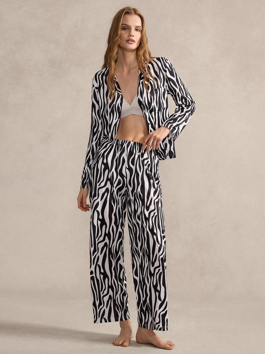 SHEIN 这款女士睡衣套装以经典的黑白斑马纹为主图案，采用翻领设计、开襟款式和简约的口袋细节。舒适的睡衣功能性与前卫的动物纹元素相结合，兼具休闲与个性。 - 黑與白 - 查看 1