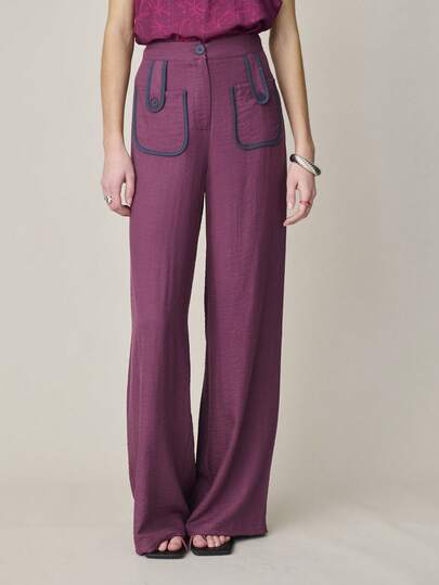 Nöista Koyu pembe ve mor renklerdeki geniş paçalı pantolon, düğme detaylı büyük ön yama cepleri ve koyu lacivert kontrast biye detayıyla dikkat çekiyor. İlkbahar, Yaz, Kadın.