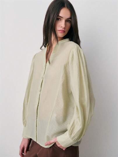 Nöista 浅色长袖衬衫，优雅大方，宽松版型，立领泡泡袖设计。采用轻盈面料，色调柔和，舒适百搭，是都市女性春夏日常穿着和通勤的必备单品。