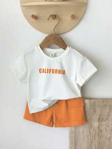 SHEIN Playful Pals Set de 2 piezas de camiseta de manga larga de cuello redondo con gráfico en inglés y pantalones cortos con bolsillo de cintura elástica para niños pequeños y bebés, ropa infantil, conjunto de niño, traje deportivo, adecuado para primavera y verano, vacaciones, fiesta - Naranja - Ver 3
