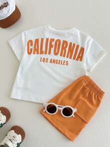 SHEIN Playful Pals Set de 2 piezas de camiseta de manga larga de cuello redondo con gráfico en inglés y pantalones cortos con bolsillo de cintura elástica para niños pequeños y bebés, ropa infantil, conjunto de niño, traje deportivo, adecuado para primavera y verano, vacaciones, fiesta - Naranja - Ver 2