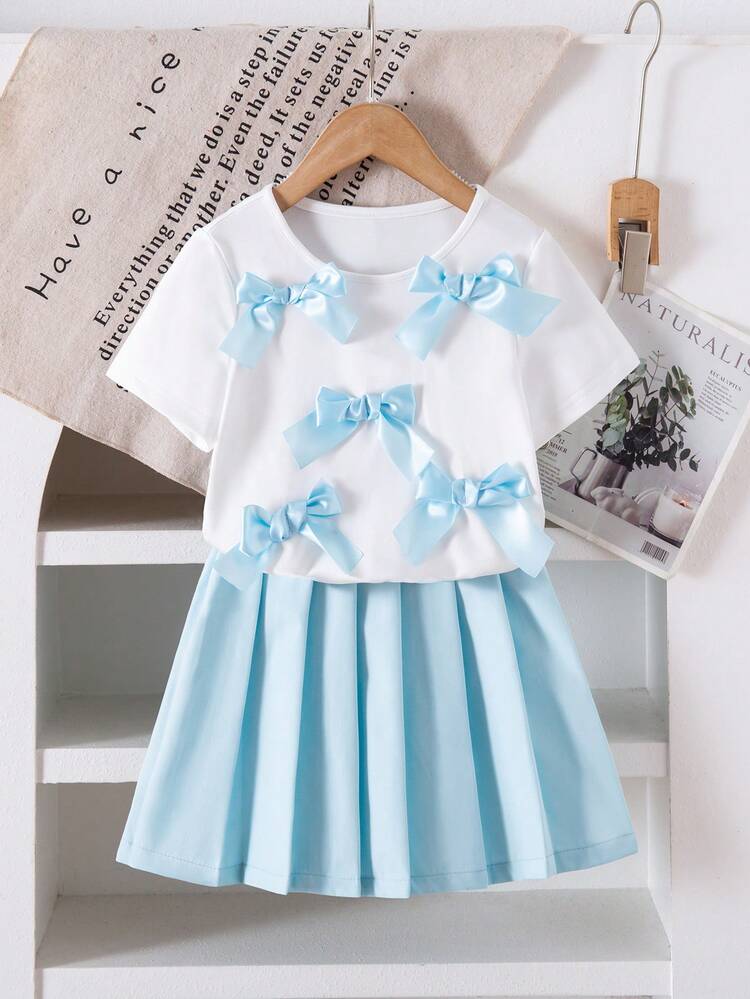 Bộ đồ bé gái phong cách Y2K ngọt ngào dễ thương gồm áo thun dệt kim tay ngắn cổ tròn thắt nơ và chân váy xếp ly mini màu trơn. - Màu xanh nhạt - Xem 1