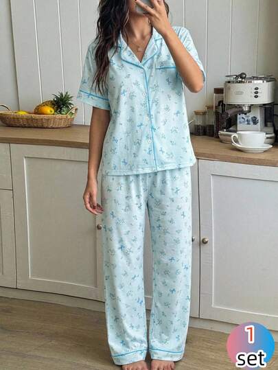 一套女童睡衣，薄荷绿蝴蝶碎花图案，短袖开衫搭配同色长裤，面料柔软透气，宽松版型，适合休闲居家穿着，设计优雅可爱，简约百搭