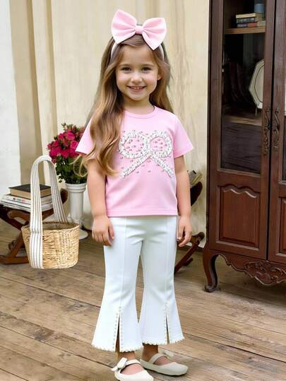 两件套女童春夏新款褶皱蝴蝶结珍珠装饰短袖圆领T恤和修身喇叭裤，浅粉色和白色搭配，适合日常穿着、运动、购物、度假、朋友聚会、户外旅行和用餐。