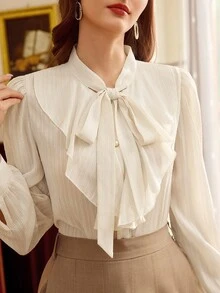 Vintamour 复古优雅女士衬衫，饰有纹理蝴蝶结、荷叶边下摆和珍珠纽扣，休闲百搭，适合工作、度假、夏季、春假、情人节等场合。优雅女士衬衫，春季女装衬衫。 - 米色 - 查看 6