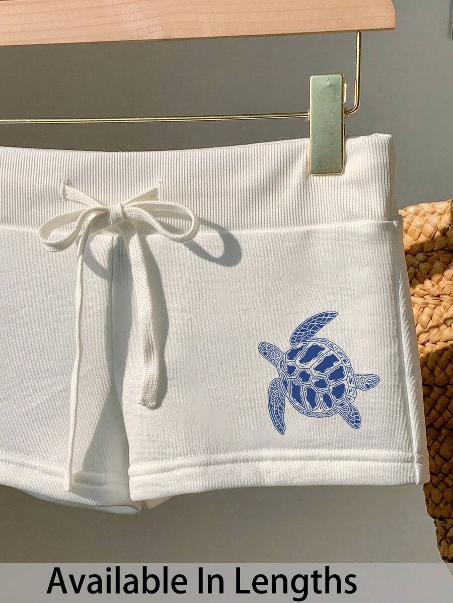 Comfortcana Quần short nữ dáng ôm màu trắng, tối giản, in hình rùa biển xanh trắng, cạp chun, dây rút – Thích hợp mặc đi biển mùa hè và nghỉ dưỡng bên bờ biển, thoải mái cho mùa xuân/hè, dễ thương, mềm mại, phong cách boho, đảo nhiệt đới, lễ hội, hẹn hò, lễ hội âm nhạc và kỳ nghỉ xuân. - trắng - Xem 1