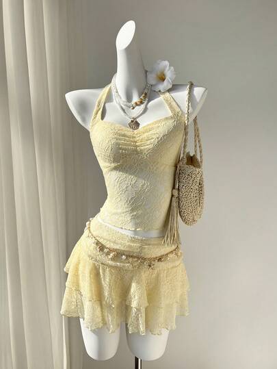 Elamini Bộ đồ 2 món gồm áo hai dây ôm sát cổ yếm buộc dây sau lưng và chân váy chữ A ngắn, chất liệu vải ren dệt kim màu vàng, trang trí sao biển kim loại, thanh lịch, ngọt ngào, dễ thương, thích hợp cho kỳ nghỉ xuân/hè, đi biển, dạo chơi hoặc hẹn hò.