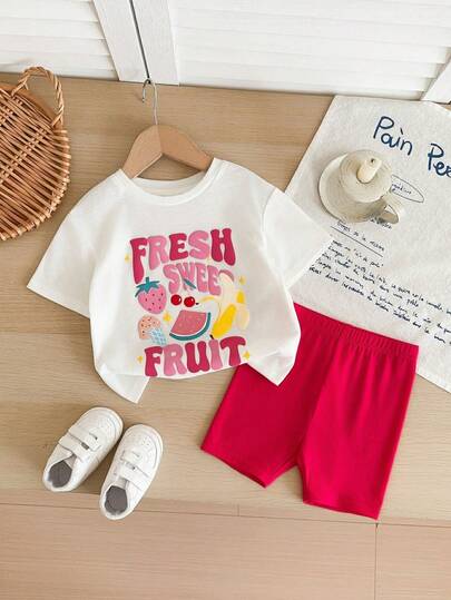 SHEIN The 2-Piece Cute Baby Girl Casual, Simple, And Adorable Knitted Stretch Graffiti Fruit Pattern White T-Shirt And Tight Shorts Set Is Suitable For Birthday Parties, Parties, Performances, Weddings, Baptisms, Opening Ceremonies, Everyday Wear, School, Outings, And Spring/Summer Seasons.
