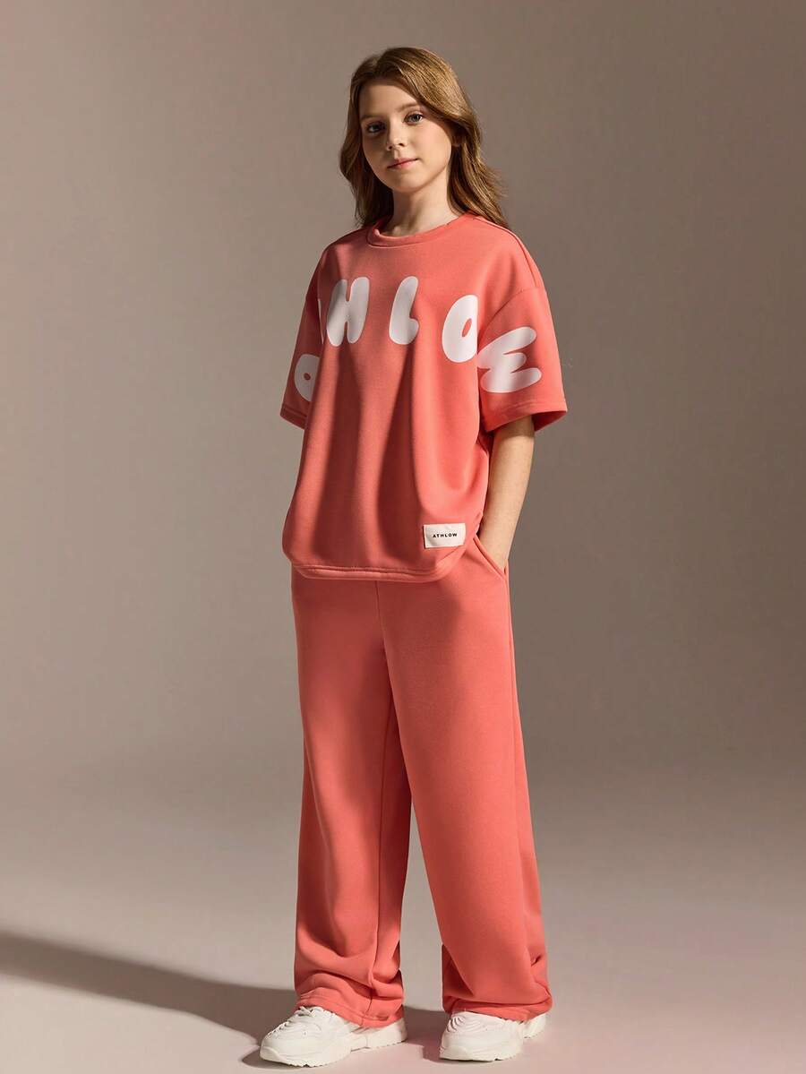 مجموعة رياضية كاجوال للفتيات المراهقات، تي شيرت فضفاض بياقة مستديرة مقترن مع بنطلون بقصة مريحة، لون برتقالي-وردي نابض بالحيوية الشبابية، قماش ناعم ولطيف على البشرة، مناسب للارتداء اليومي الكاجوال، المدرسة، والعطلات - البرتقالي مرهق - مشاهدة 1