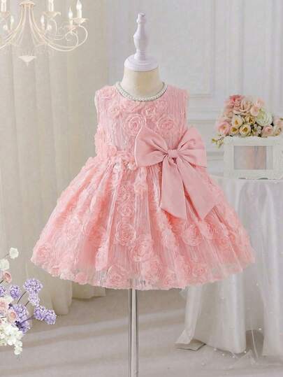 SHEIN 女婴立体蝴蝶结A字连衣裙。精致的花朵图案增添了一丝活力与生机。A字裙摆设计优雅大方，尽显小女孩的甜美气质。无论是玩耍、居家、花园派对还是特殊场合，都能让小公主自信闪耀，成为众人瞩目的焦点。