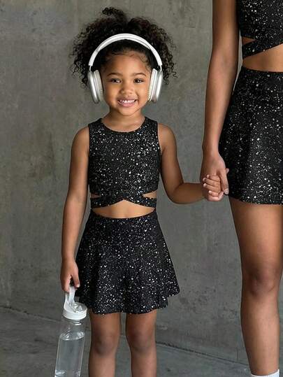 SHEIN Conjunto de camiseta y falda negra de moda para niñas, acentuado con decoración de lámina de plata brillante para añadir un encanto elegante. Hecho de tela suave y elástica para un movimiento cómodo, adecuado para clases de baile, juegos animados o salidas casuales con estilo.