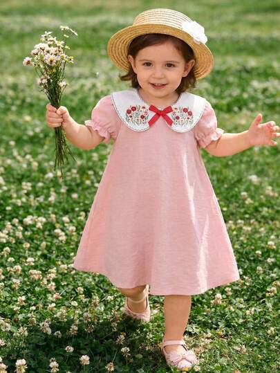 女童宽松连衣裙，浅粉色底，泡泡袖，超大领子，柔软舒适，复古花卉刺绣领口和蝴蝶结设计，适合日常穿着。