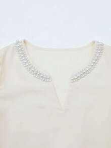 GlowEve 香槟色女士优雅圆领V领短袖休闲泡泡袖衬衫，饰以珍珠，宽松版型，适合通勤和日常穿着，尽显优雅气质。这款衬衫优雅休闲，适合女性日常穿着，也适合浪漫约会、情人节、商务办公等场合，是时尚休闲通勤、商务办公、日常休闲以及都市教师职业装的理想之选。 - 杏色 - 查看 4