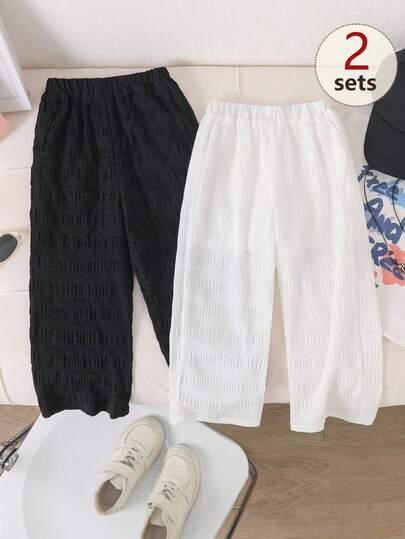 Conjunto de 2 peças (preto + branco) com calça pantalona plissada texturizada para meninas, ideal para primavera e verão. Confeccionada em tecido texturizado macio e agradável ao toque, a calça pantalona solta é perfeita para diversas ocasiões. As cores preto e branco são versáteis e combinam com qualquer roupa. Possui cintura elástica confortável e textura suave e fluida, tornando-a ideal para o dia a dia e passeios.