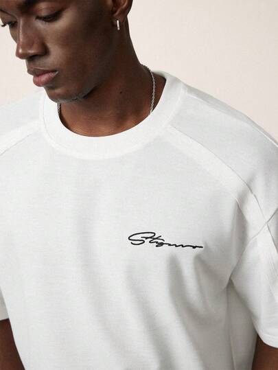 STYNVO Camiseta de manga corta y cuello redondo para hombre, camiseta blanca, camiseta gráfica blanca minimalista con bordado de letra, camiseta blanca holgada para hombre, camiseta de hombro caído para hombre, camiseta gráfica para hombre