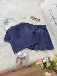 SHEIN Bộ đồ hai mảnh màu xanh navy mùa hè này gồm áo thun ngắn tay cổ tròn và chân váy xếp ly cạp cao, mang đến phong cách học đường thời trang, đơn giản, thoải mái và ngọt ngào. Được làm từ vải dệt kim, chất liệu có độ dày vừa phải và ôm sát cơ thể. Tay áo và thân váy được trang trí bằng nơ trắng, rất phù hợp cho trường học, các hoạt động ngoại khóa, thư giãn tại nhà và tham dự các bữa tiệc, v.v. - Màu xanh hải quân - Xem 2