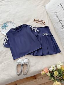SHEIN Bộ đồ hai mảnh màu xanh navy mùa hè này gồm áo thun ngắn tay cổ tròn và chân váy xếp ly cạp cao, mang đến phong cách học đường thời trang, đơn giản, thoải mái và ngọt ngào. Được làm từ vải dệt kim, chất liệu có độ dày vừa phải và ôm sát cơ thể. Tay áo và thân váy được trang trí bằng nơ trắng, rất phù hợp cho trường học, các hoạt động ngoại khóa, thư giãn tại nhà và tham dự các bữa tiệc, v.v. - Màu xanh hải quân - Xem 3