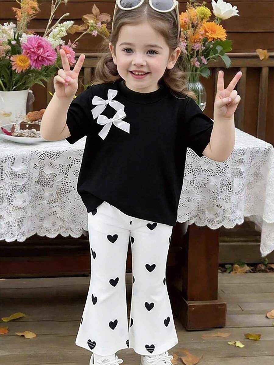 SHEIN Playful Pals 女童休闲时尚T恤上衣,蝴蝶结拼接设计,搭配喇叭裤,显腿长显高,夏季新款女童T恤套装,休闲运动装,心形印花裤套装 - 黑色 - 查看 1